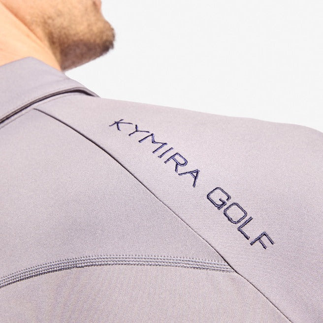 Model wearing KYMIRA Men's Infrared Golf Polo Shirt from the Strike Collection in active play, demonstrating the functional and stylish appeal of the shirt.