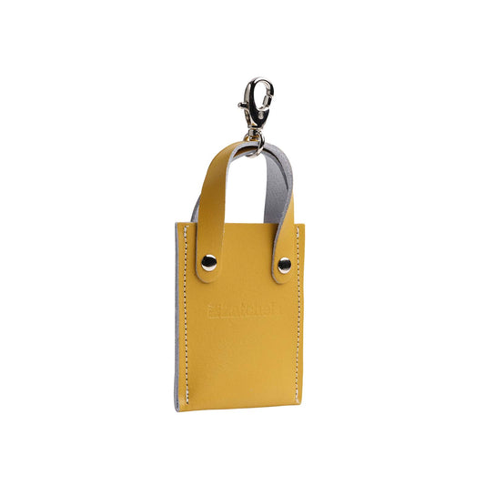 Ochre yellow leather mini tote bag charm handcrafted in England, measuring 70 x 125 mm, showcasing elegance and sophistication.