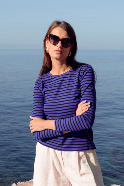 Flat lay of a women's striped crew neck t-shirt in organic cotton, paired with denim and accessories, showcasing its style potential for casual outings.