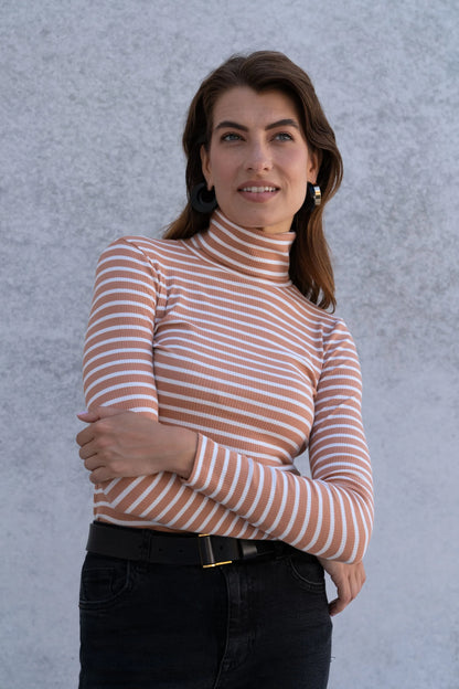 Versatile luxury women's striped roll neck top styled for casual wear, layered under a coat during transitional weather.