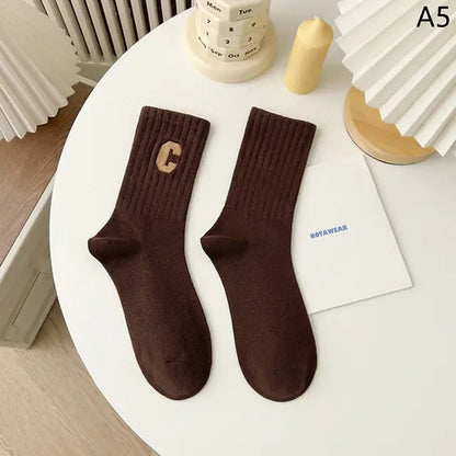 Rich brown middle tube socks featuring a stylish design, embodying luxury and versatility for all-day wear.