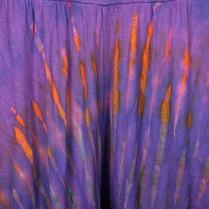 Model wearing high waist tie dye harem pants in olive green, styled with a chic top for an effortlessly luxurious ensemble.