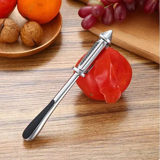 Modern minimalist multi-functional vegetable and fruit peeler elegantly positioned on a ripe tomato, surrounded by assorted fruits and nuts, showcasing its sleek design and practical use.