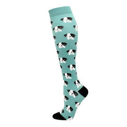 Women's Knee Length Compression Travel Socks for Comfort, Style, and Circulation showcasing a playful mint backdrop with charming dog face prints, adding a whimsical touch to travel.