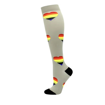 Women's Knee Length Compression Travel Socks for Comfort, Style, and Circulation adorned with playful rainbow heart designs on a soft grey backdrop, merging style with compassion.
