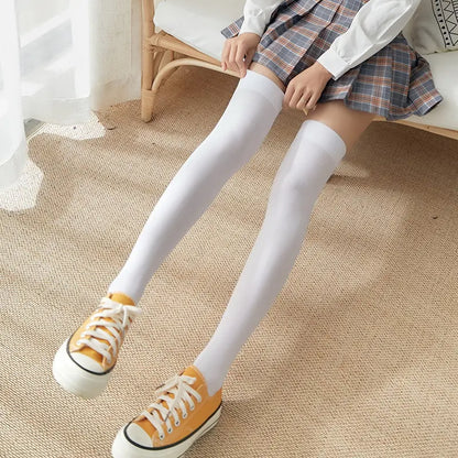 Women's Black White Solid Color Long Socks Stockings displayed on a model wearing a plaid skirt and yellow sneakers, showcasing the sleek white design.