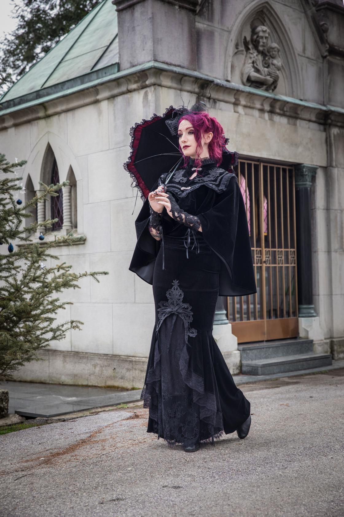 Luxurious Dark In Love Velvet Lark Capelet featuring exquisite embroidery and lace detailing, perfect for adding dramatic elegance to any ensemble. Crafted in sumptuous black velvet with ornate clasp fastenings, measuring 15" at the front and 26" at the back.