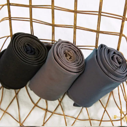 Three rolled pairs of Women's Luxury Transparent Fishnet Tights in varying shades displayed in a stylish wire basket, emphasising seasonal versatility.