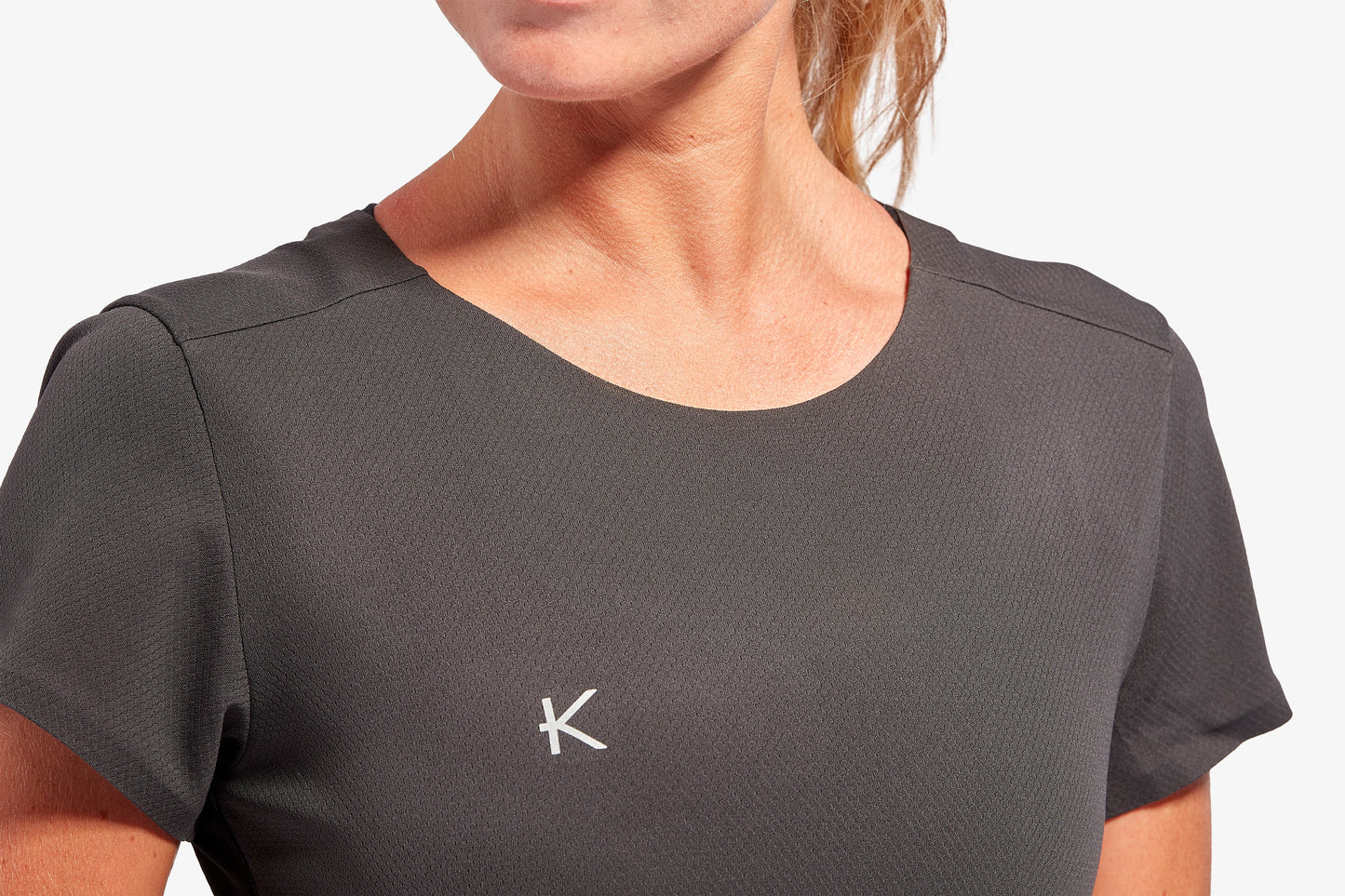 Stylish KYMIRA Women's Performance T-Shirt with pleated back, highlighting luxury and functionality for active women.
