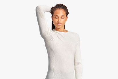 High-quality women's merino wool baselayer top by KYMIRA, designed for stylish comfort and performance with expandable side and arm panels.