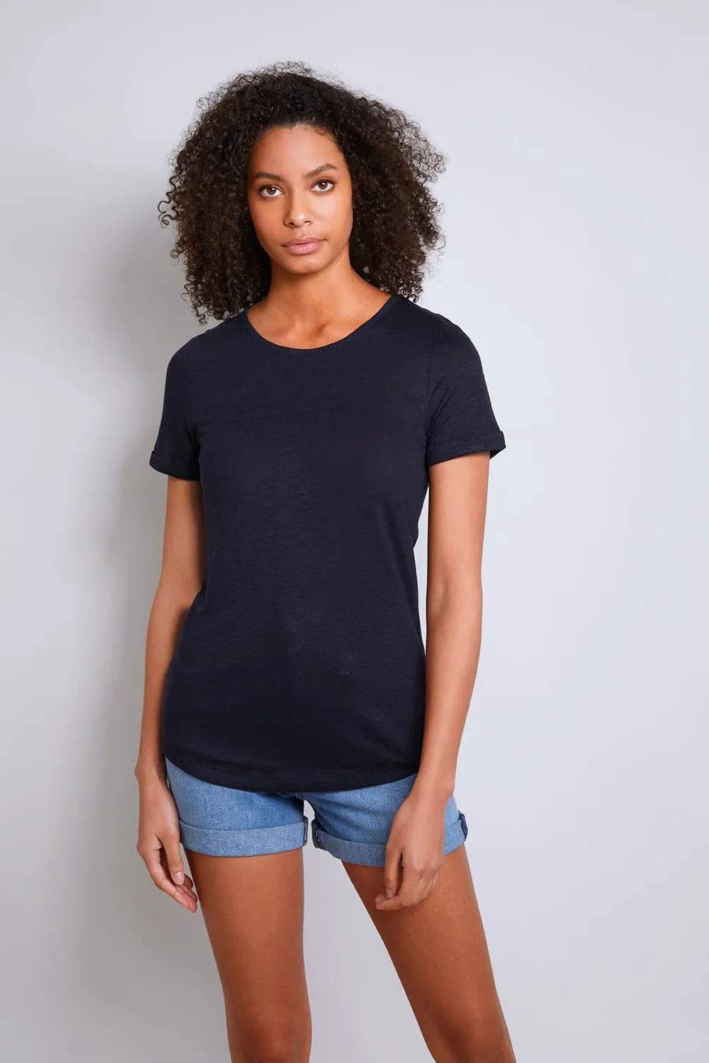 Elegant women's 100% linen t-shirt displayed on a model, featuring a relaxed fit and classic crew neck design for sophisticated comfort.
