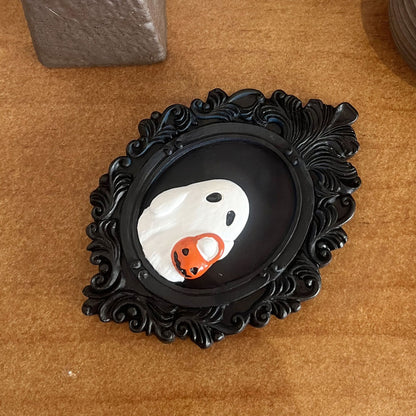Halloween Resin Ornaments Trick Or Treat Ghost Wall Decoration showcasing a charming ghost with a pumpkin basket, beautifully displayed in an ornate black frame, ideal for sophisticated Halloween home styling.