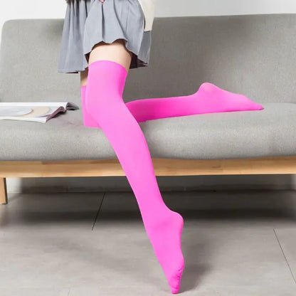 Vibrant Women's Black White Solid Color Long Socks Stockings displayed with a chic pink hue and a trendy grey skirt on a contemporary couch.