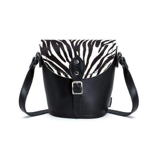 Luxurious handmade leather barrel bag in unique zebra print, showcasing adjustable strap and exquisite hair-on finish.