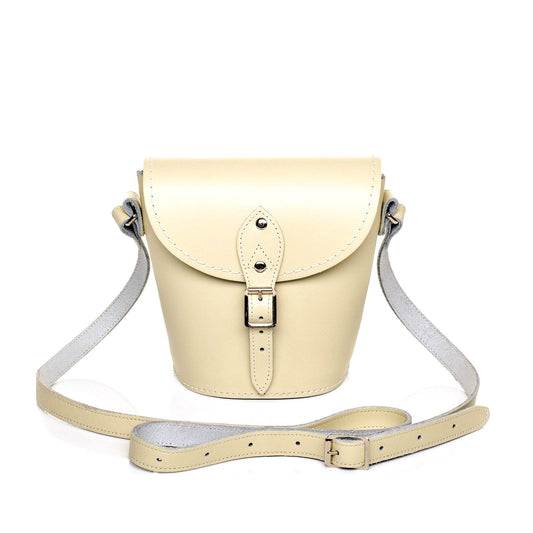 Elegant pastel cream handmade leather barrel bag by Zatchels with adjustable strap and customisation options, perfect for sophisticated outfits.
