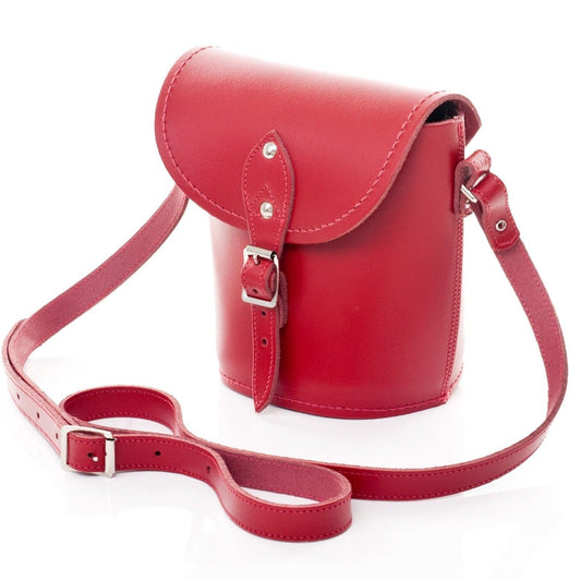 Close-up of the adjustable strap on a red leather barrel bag, highlighting the premium quality leather and stylish silver nickel buckle for sophisticated accessorising.