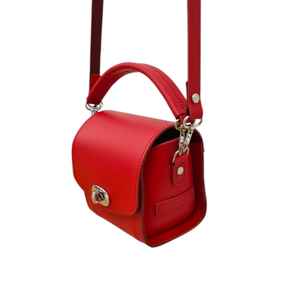 Close-up of the Handmade Bauble Leather Handbag features eye-catching Pillar Box Red hue, heart charm, and premium leather material, perfect for chic occasions.