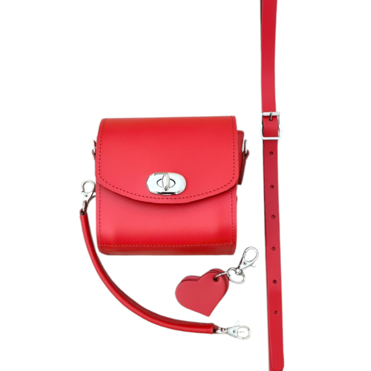 Handmade Bauble Leather Handbag in Pillar Box Red featuring a heart charm, elegantly showcased against a minimalist background, highlighting its luxurious craftsmanship and chic design.