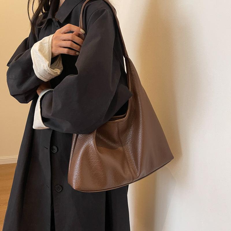 Stylish luxury faux leather shoulder bag in black with sleek gold hardware, perfect for elevating everyday outfits for sophisticated women.