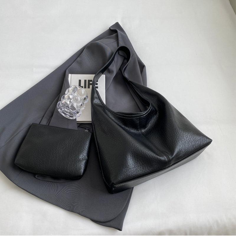 Stylish women's faux leather shoulder bag with gold accents, highlighting luxury and fashion-forward design.