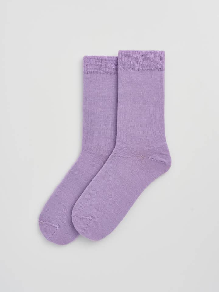 Stylish Merino Wool calf-length socks paired with fashionable attire, emphasizing elegance and functionality for the discerning wearer.