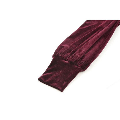 Flared skirt of the burgundy velvet dress paired with gothic lace embellishments, showcasing a fashionable silhouette.