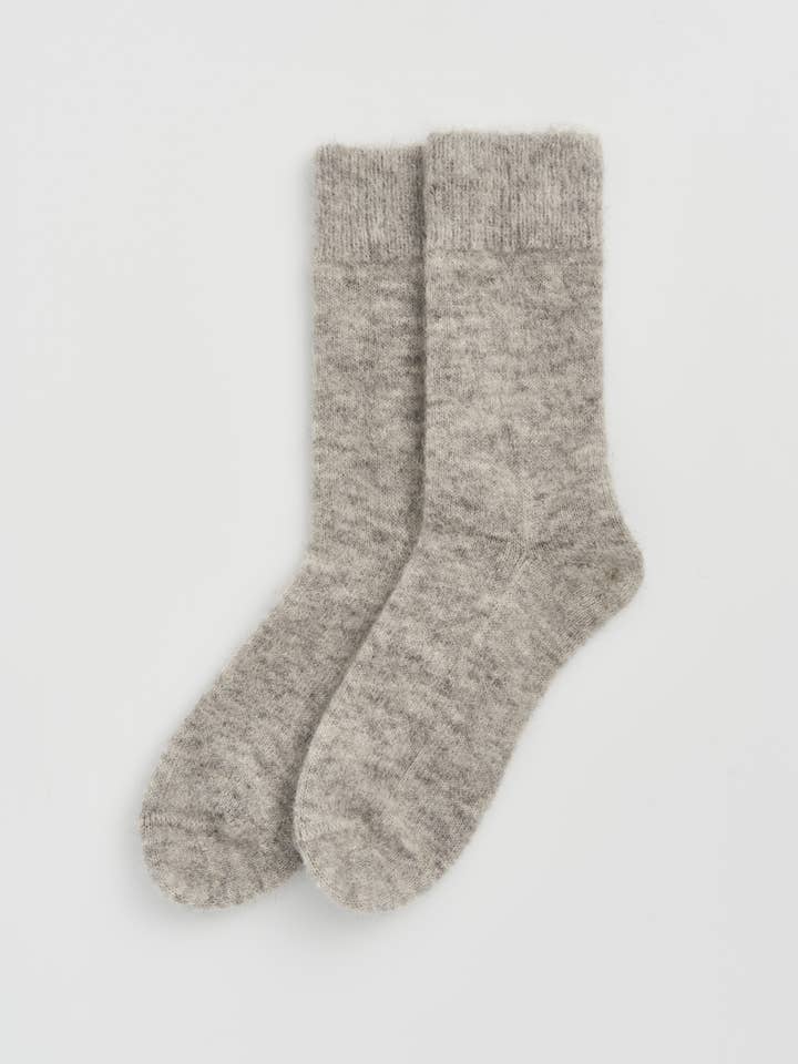 Beautifully crafted alpaca bed socks displayed on a plush surface, illustrating their soft fabric blend for luxurious warmth.