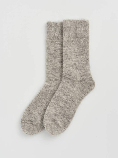 Beautifully crafted alpaca bed socks displayed on a plush surface, illustrating their soft fabric blend for luxurious warmth.