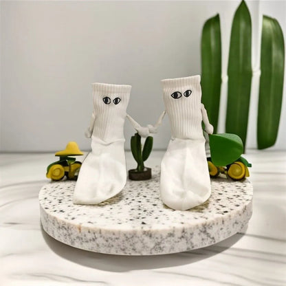 Charming presentation of Novelty Romantic Magnetic Holding Hands Couple Socks, featuring two socks 'holding hands' on a decorative display, ideal for a romantic gift.