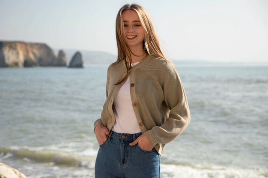 Close-up of a women's organic cotton cardigan with textured knit and stylish wooden buttons, exemplifying luxury and comfort.