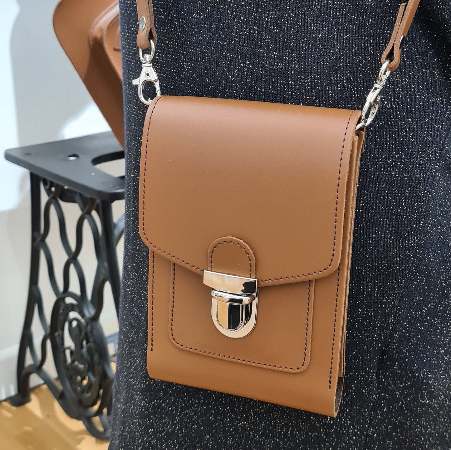 Close-up of Zatchels Luxury Leather Crossbody Phone Case, highlighting the adjustable strap and secure push lock closure.