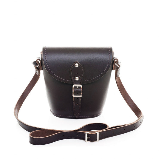 Luxury handmade dark brown leather barrel bag with adjustable strap, showcasing exquisite craftsmanship and sophisticated design.