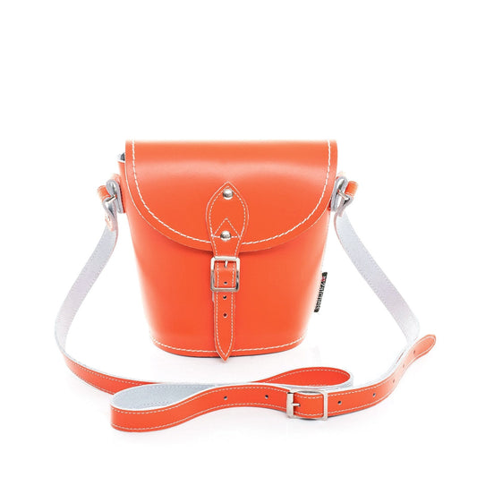 Handmade orange leather barrel bag by Zatchels featuring adjustable strap and customizable options, showcasing exquisite craftsmanship and luxury design.