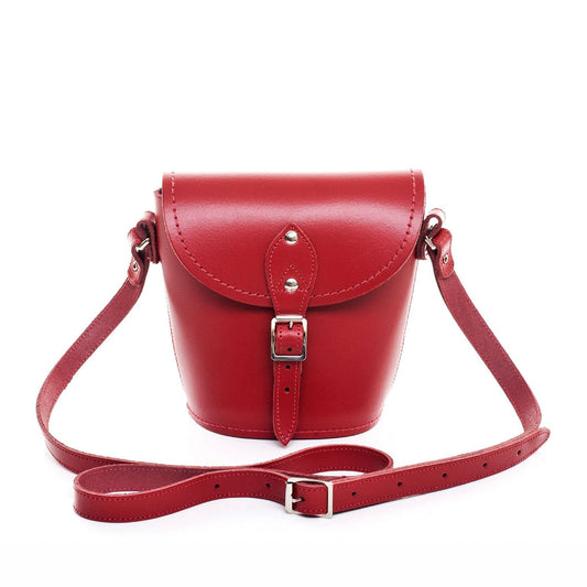 Handmade red leather barrel bag with adjustable strap, showcasing exquisite craftsmanship and elegant design, ideal for luxury fashion enthusiasts.