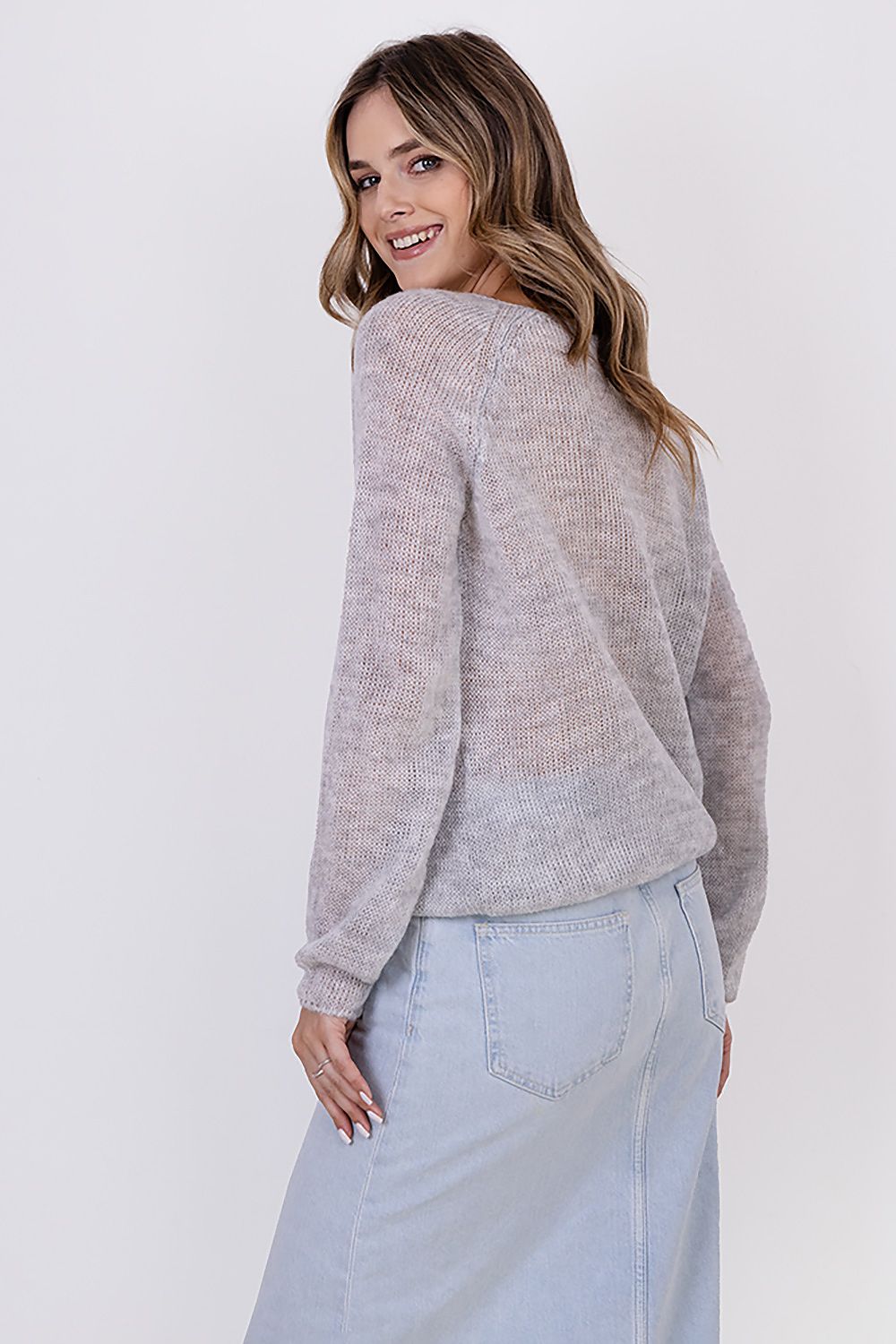 Model wearing MKM lightweight transparent sweater, showcasing a sophisticated look for colder seasons with comfort and style.