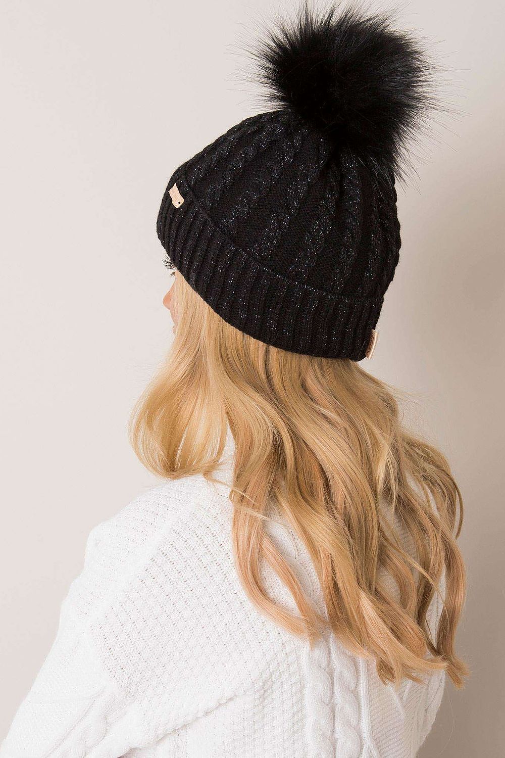 Flat lay of Rue Paris women's winter beanie in plaid design with pom-pom, representing luxury and comfort for the winter season.