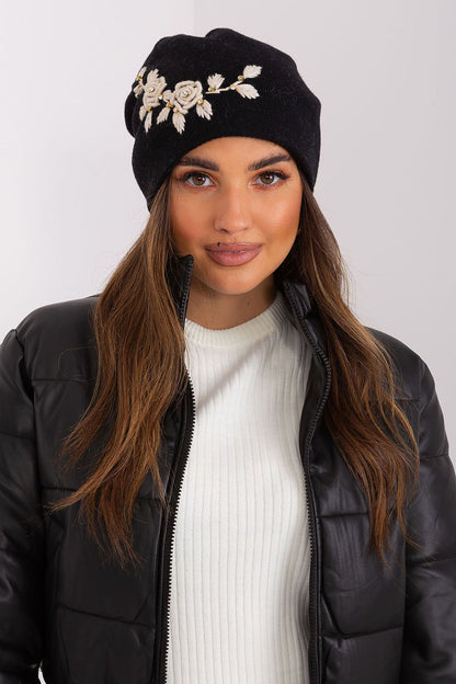 Elegant women's winter hat from AT, designed in a soft knit with decorative applique detailing, providing luxurious comfort with a mix of acrylic, cotton, and cashmere.