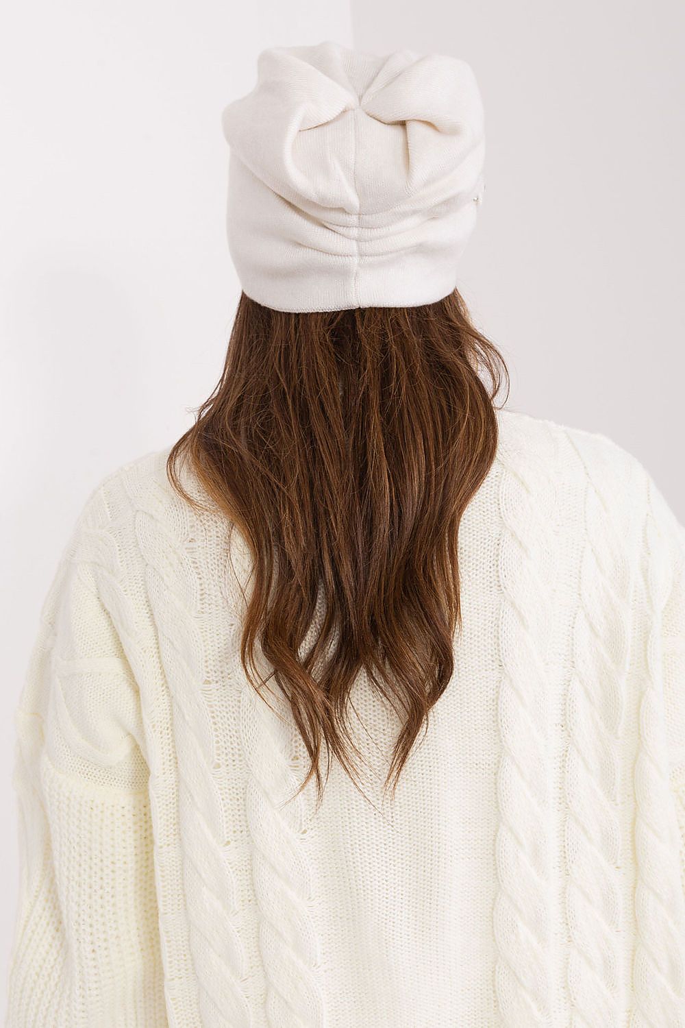 Stylish knitted winter hat for women by AT, featuring a stunning decorative applique and luxurious fabric composition, ideal for seasonal elegance.