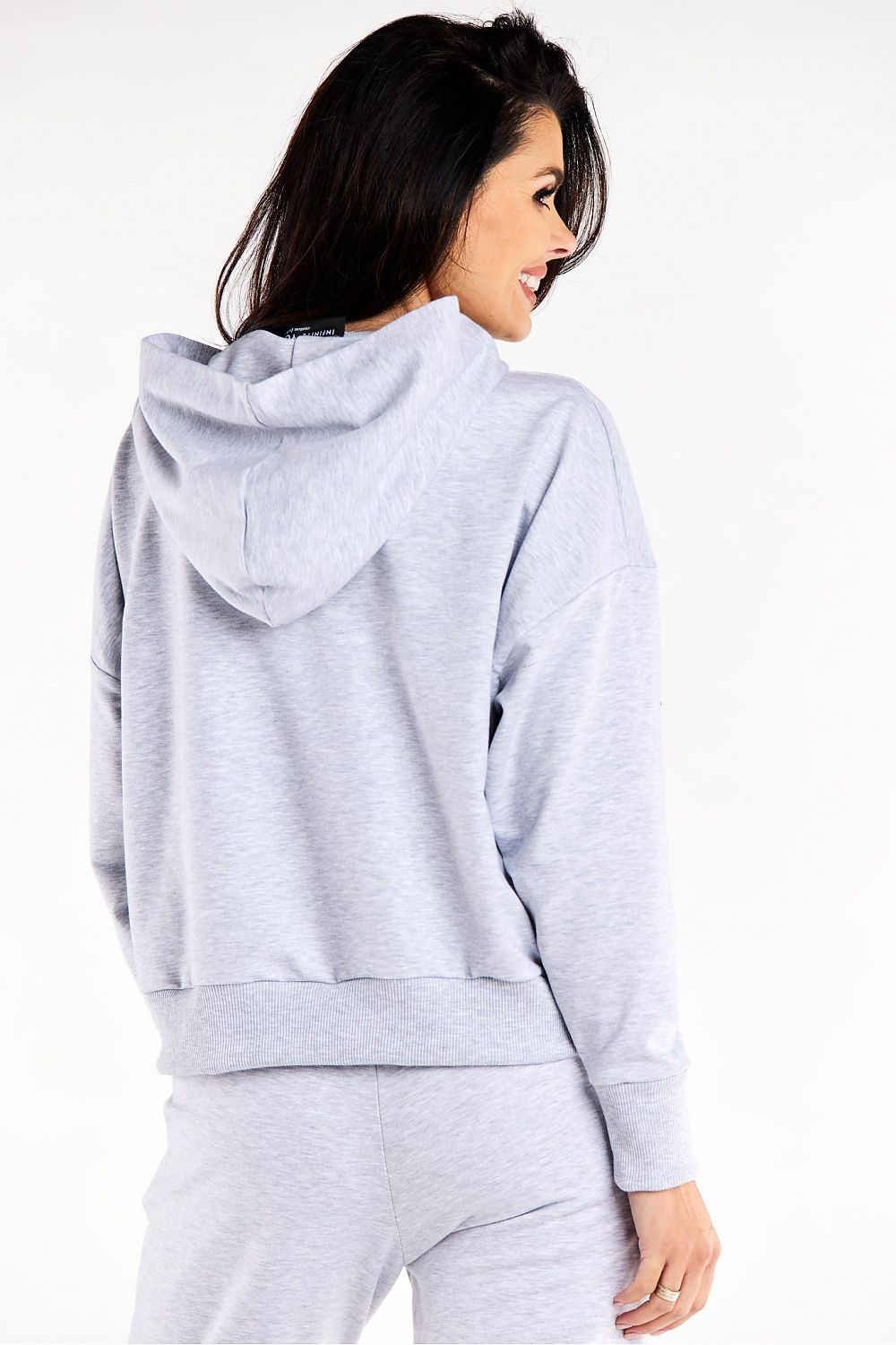 Model wearing the Luxurious Infinite You Loose Sweatshirt With Hood, illustrating its relaxed fit and generous kangaroo pocket for ultimate comfort.