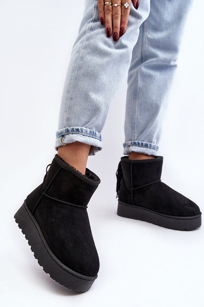 Sophisticated black ankle snow boots featuring fur lining and stylish tassel detail by Step in Style, elegantly worn with trendy jeans for a fashionable appeal.