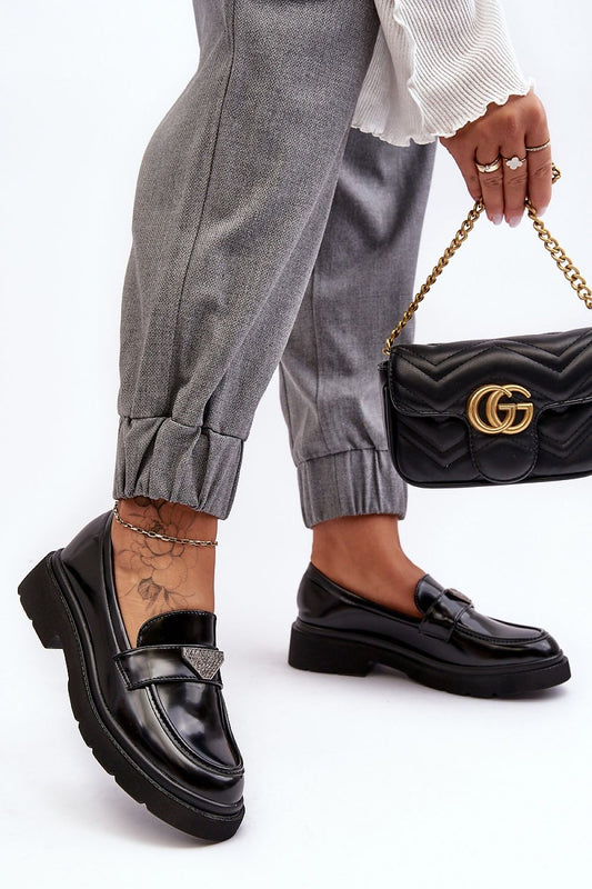 Chic black eco leather half shoes with a decorative strap, paired with grey trousers and a designer bag, embodying luxury fashion by Step in Style.