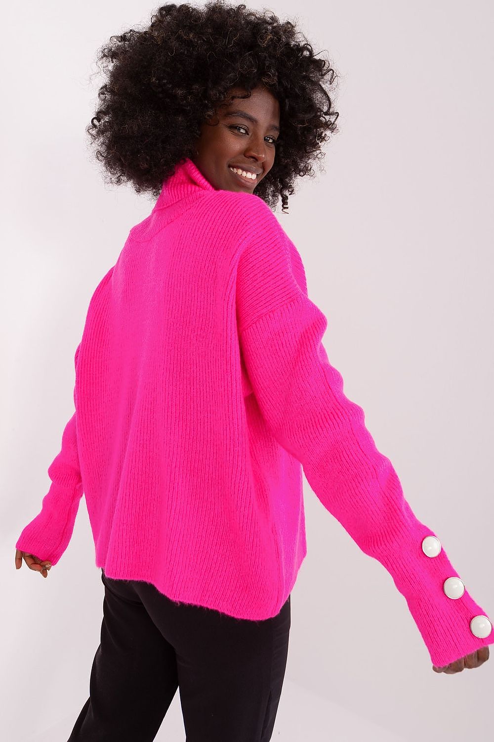 Close-up of decorative buttons on the luxurious long sleeve turtleneck sweater by Badu in soft acrylic fabric.