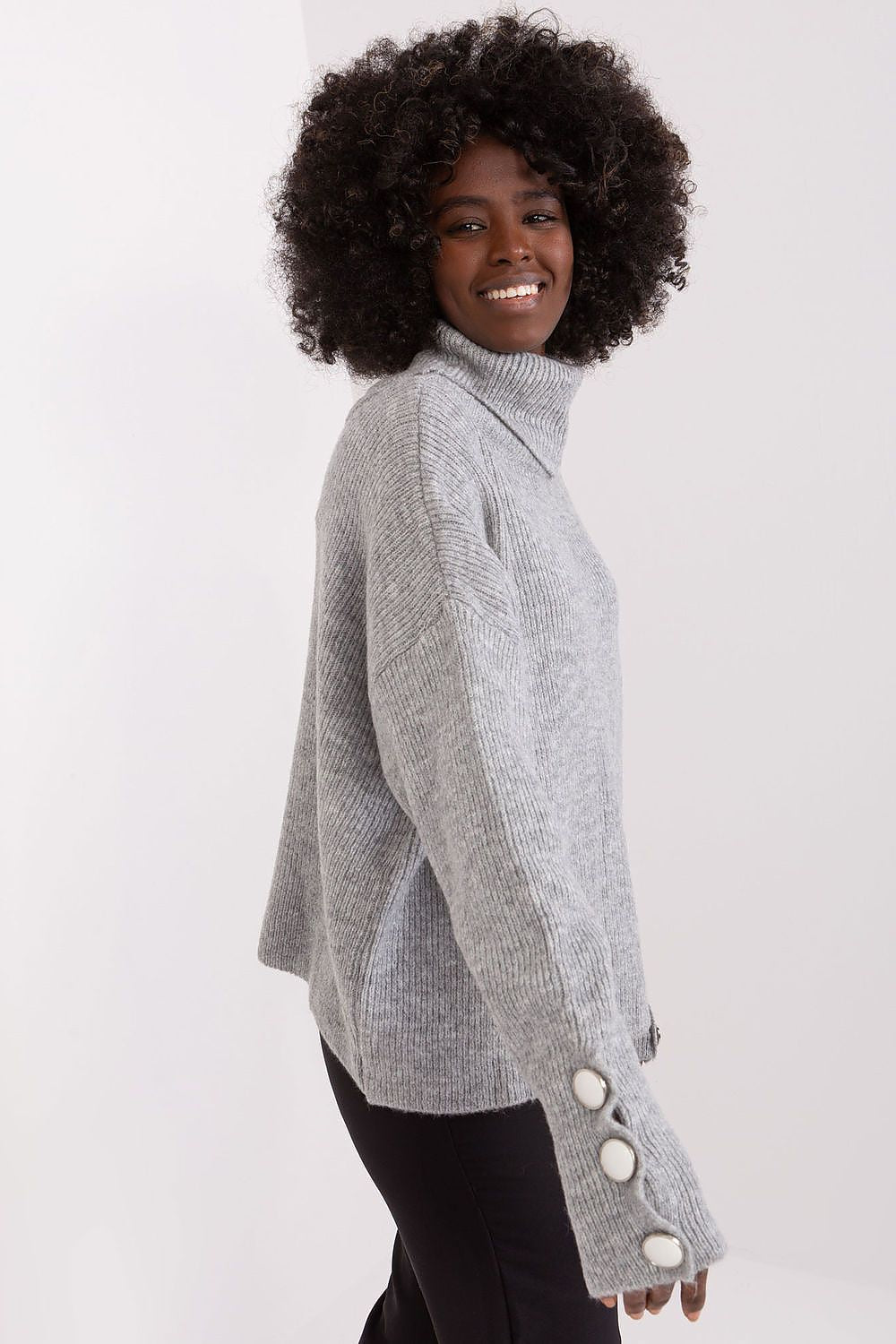 Detail view of the ribbed texture and fashionable design of Badu's long sleeve turtleneck sweater in high-quality acrylic.