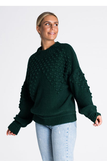 Stylish Figl long sleeve sweater showcasing ribbed cuffs and hem, adorned with pom-poms for a touch of sophistication.