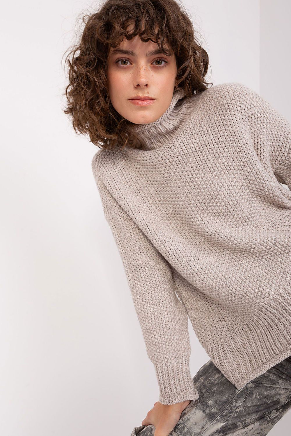 Close-up of Badu's luxurious women's turtleneck sweater, highlighting the soft texture of the acrylic and wool fabric in a minimalist style.