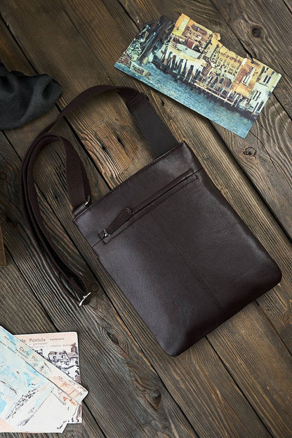 Close-up view of Galanter's aged natural leather shoulder bag, highlighting the luxurious texture and zippered compartments for a sophisticated accessory look.