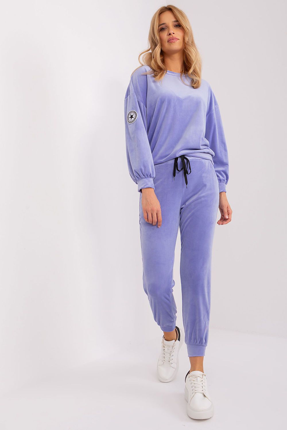 Elegant velour knit sweatshirt and tapered pants set by Italy Moda, featuring pockets and a signature patch, perfect for chic casual wear.