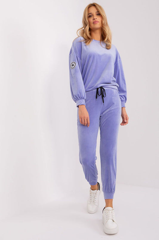 Elegant velour knit sweatshirt and tapered pants set by Italy Moda, featuring pockets and a signature patch, perfect for chic casual wear.