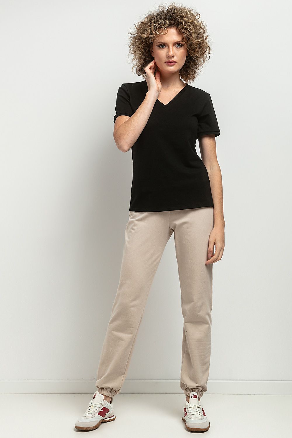 Elegant slim-fit V neckline blouse by Tessita, crafted from OEKO-TEX certified cotton knit, showcasing a delicate cuffed sleeve and decorative pleat for a luxurious touch.