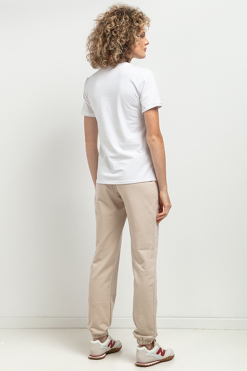 Elegant slim-fit V neckline blouse by Tessita, crafted from OEKO-TEX certified cotton knit, featuring a feminine silhouette and delicate cuffs, perfect for upscale casual or formal wear.